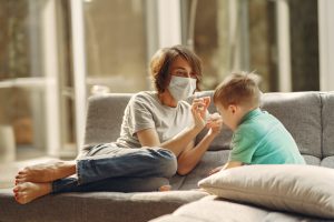 woman with mask stays home and plays with son during covid19